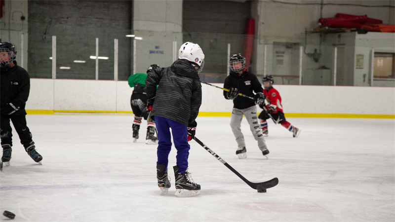 Kids playing hockey at an ice rink