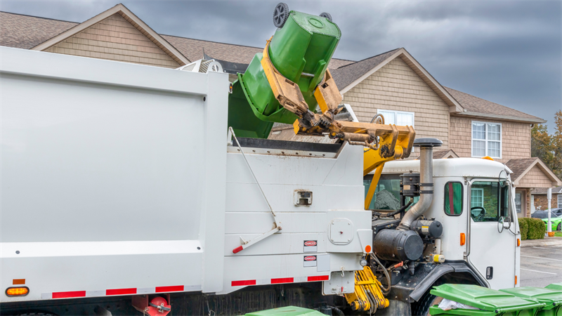Garbage truck picking up garbage bin